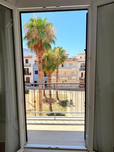an open door to a balcony with palm trees at Casa Ferrante in Cinisi