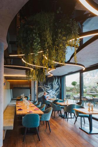a restaurant with tables and chairs and a ceiling with plants at Hotel Acherl in Achenkirch