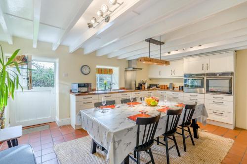 a kitchen with a table and some chairs and a kitchen with at Seata Barn in Askrigg