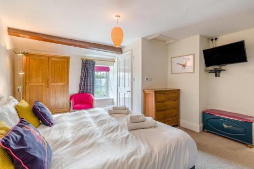 a bedroom with a large white bed and a tv at Seata Barn in Askrigg