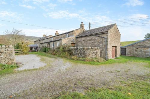 an old stone house on a dirt road at Seata Barn in Askrigg