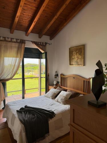 a bedroom with a large bed and a large window at Villa Atlántica in Ribeira