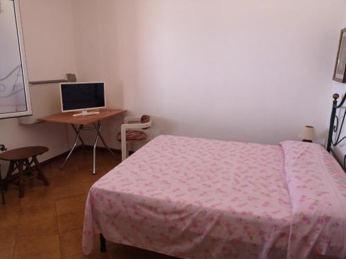 a bedroom with a bed and a desk with a computer at Villa Adele in Trappeto