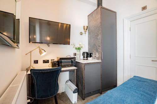 ダブリンにあるHowth Harbour Cosy Retreatのデスク、電子レンジ、ベッドが備わる客室です。