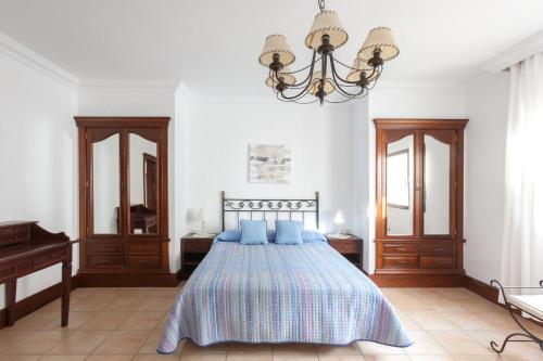 Los VallesにあるBellavista, piscina privada climatizada y saunaのベッドルーム1室(青い枕とシャンデリア付きのベッド1台付)