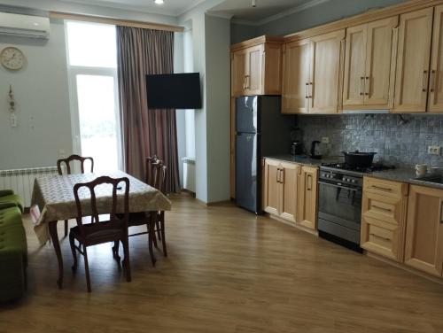 a kitchen with a table and a black refrigerator at Two bedroom apartment Mikheil in Kutaisi