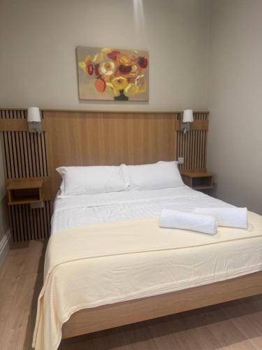 a large bed in a bedroom with a painting on the wall at Milton on The Moyle Apartments in Buncrana