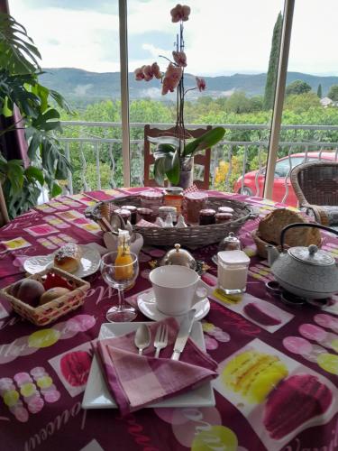a table with a pink table cloth with food on it at LA GRAND'VIGNE in Chauzon