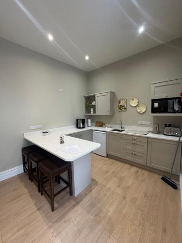 a large kitchen with a large white counter top at Milton on The Moyle Apartments in Buncrana