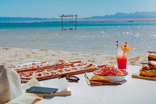 a table on the beach with food and a drink at The Kaktus Somabay in Hurghada