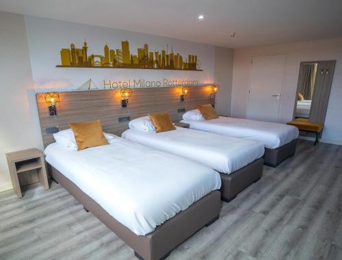 a room with three beds in a hotel mirror residence at Hotel Milano in Rotterdam