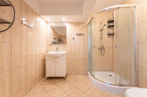 a bathroom with a shower and a sink and a toilet at DIUNA Łeba in Łeba
