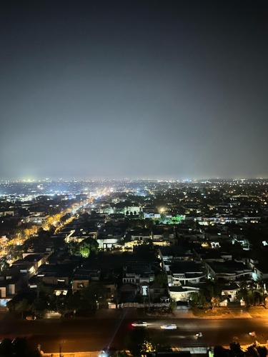 a view of a city at night with lights at Luxury Apartments at Goldcrest Mall and Residency DHA Phase 4 by Nirvana Nests in Lahore