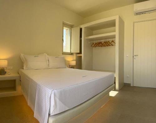 a bedroom with a large white bed with a table at Sohoro Villas in Koufonisia