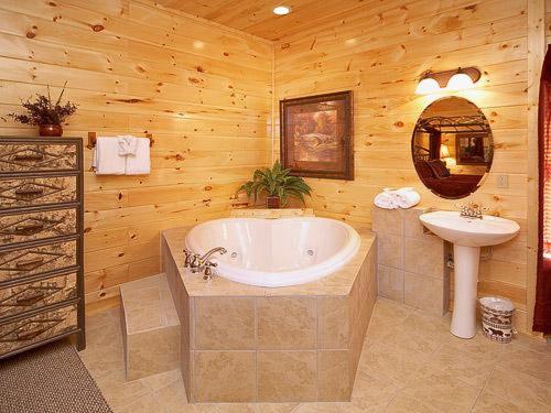 La salle de bains est pourvue d'une baignoire et d'un lavabo dans une cabine. dans l'établissement Chalet D'Amour Holiday home, à Gatlinburg