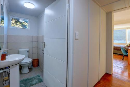 a white bathroom with a toilet and a sink at Casa Dal Mare in Knysna