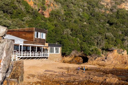 a building on a beach next to a mountain at Casa Dal Mare in Knysna