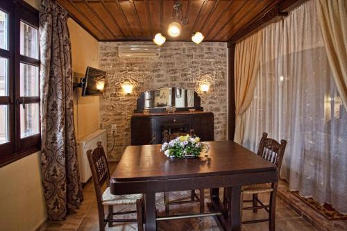 uma sala de jantar com uma mesa com flores em Erontas em Argyroupolis