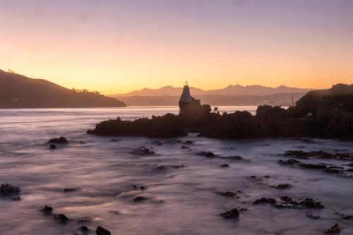 a sunset over a body of water with a church at Casa Dal Mare in Knysna