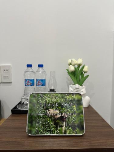 a book sitting on a table with flowers and water bottles at Nhà Lười in Hue