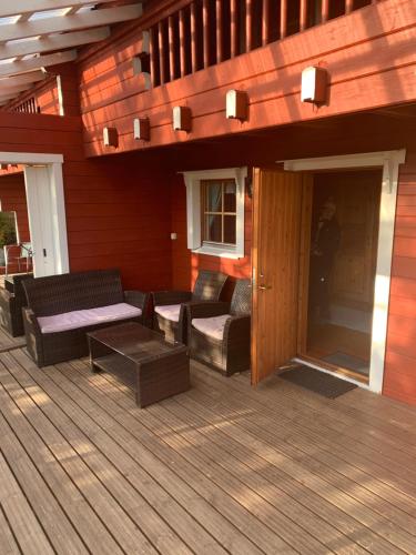 a wooden deck with furniture on a house at Lomahyppäys in Naantali
