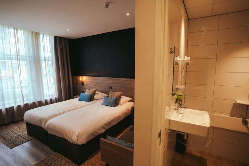 a hotel room with a bed and a sink at Hotel Milano in Rotterdam