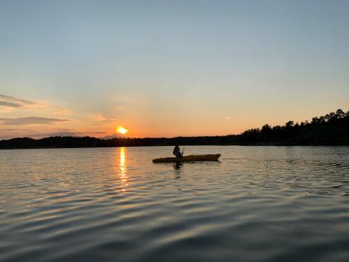 a man in a boat on a lake at sunset at Lomahyppäys in Naantali