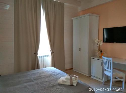 a bedroom with a bed and a desk and a tv at Le Camelie in Ginosa Marina