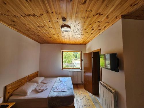 a bedroom with a bed with a wooden ceiling at Hotel Vermoshi TDC in Vermosh