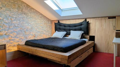 una camera con letto in legno e lucernario di Gites Les Cordées Liées ad Albi