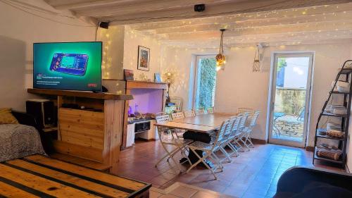 ein Wohnzimmer mit einem Tisch und einem Fernseher in der Unterkunft Gites Les Cordées Liées in Albi