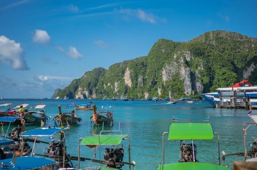 a group of boats in the water next to a mountain at Phi Phi at Pier in Phi Phi Don