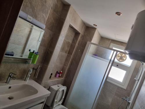 a bathroom with a shower and a toilet and a sink at فيلا فاخرة بتصميم أنيق in El Alamein