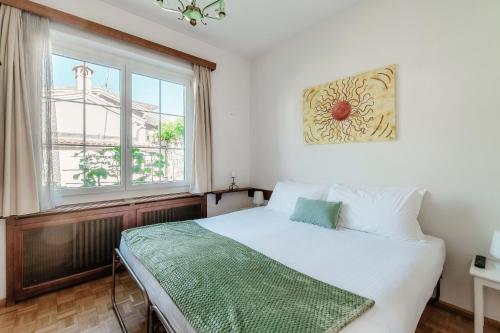 a bedroom with a white bed and a window at Al Capriccio Apartment by Quokka 360 - 5 minutes from the centre of Ascona in Losone