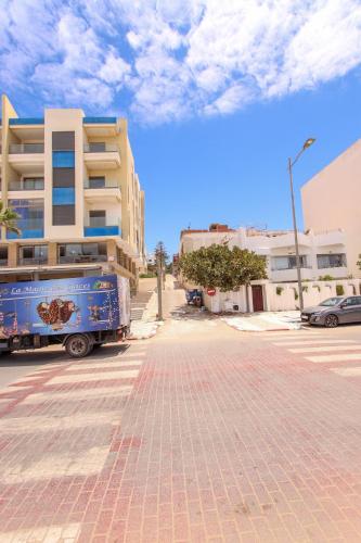a blue truck parked in front of a building at La Marina Vivez l'expérience Mehdia à 100m de la plage in Kenitra