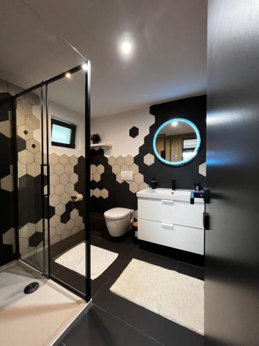 a bathroom with a toilet and a sink and a mirror at The Landscape Barn Homes in Râşnov