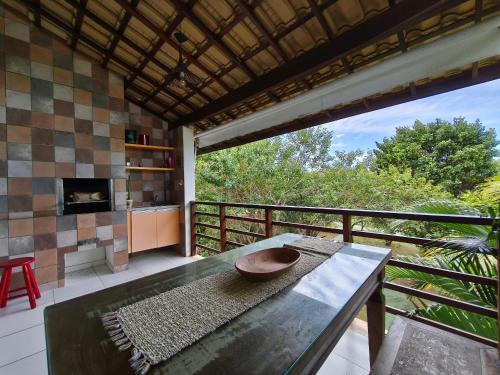 d'un salon avec une table et un balcon. dans l'établissement Reserva Imbassaí Apartamento 1 quarto área de churrasco Bl2202, à Mata de São João