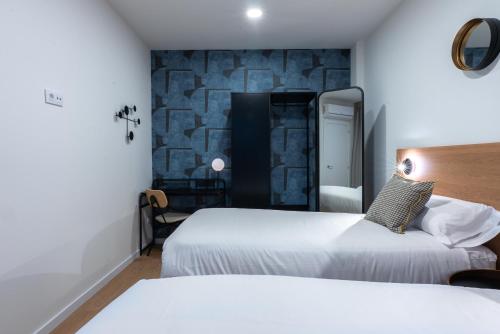 a hotel room with two beds and a stone wall at Smartr Valencia Turia in Valencia