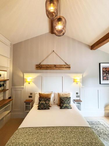 a bedroom with a large white bed with two pillows at Accommodation Bristol Airport in Redhill