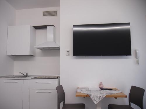 a kitchen with a table and a tv on the wall at Hotel Vienna in Pesaro