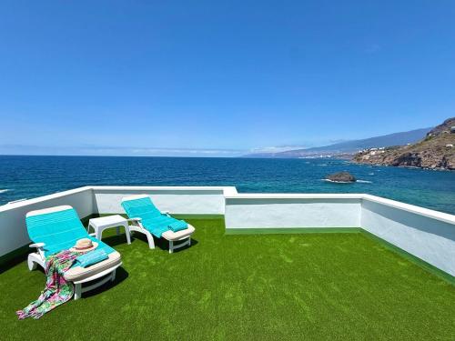 a balcony with two chairs and a view of the ocean at Casa Ale, Stunning Sea Views in Las Aguas