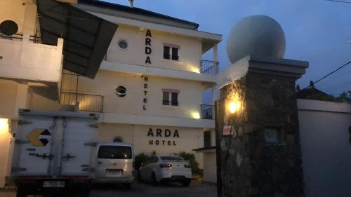 a building with a car parked in front of it at Hotel Arda Bali in Negara
