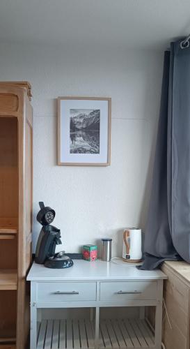 a white dresser with a cat sitting on top of it at Appartement avec forêt et vue, 2 chambres in Égat