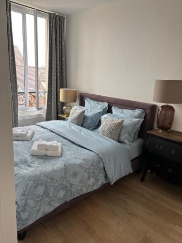 a bedroom with a bed with blue sheets and a window at Cocoon Retreat in Chantilly