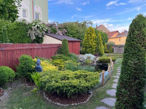 a garden with bushes and a fence and a pond at Lomnice nad Popelkou v srdci českého ráje in Lomnice nad Popelkou
