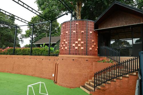 a brick tower with a staircase next to a building at Swiss Holidays in Pinangode