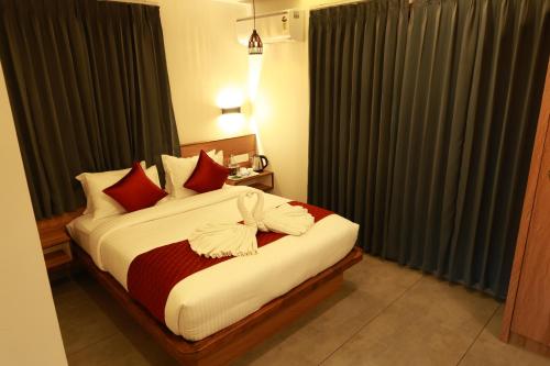 a bedroom with a bed with red and white pillows at Swiss Holidays in Pinangode