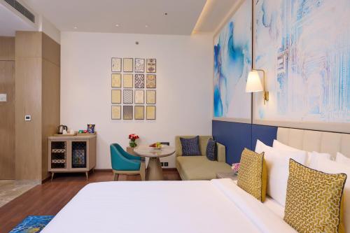 a hotel room with a bed and a table at Sarovar Premiere Amritsar in Amritsar