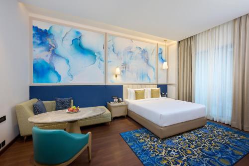 a hotel room with a bed and a table and a table at Sarovar Premiere Amritsar in Amritsar