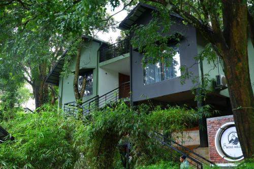 a house in the woods with a tree at Swiss Holidays in Pinangode